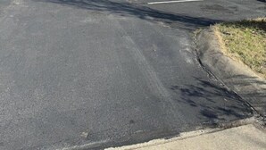 A row of motel rooms with a parking lot in front. - Somatel Goodlettsville (Goodlettsville)