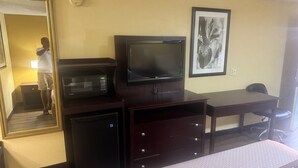 A hotel room with a bed, a TV, a microwave, a desk, and a chair. - Somatel Goodlettsville (Goodlettsville)