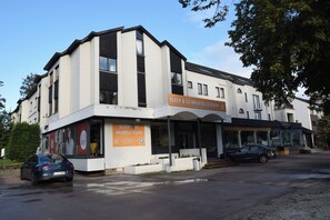 A two-story building with a sign for 'Sleep & Go Brussels South' indicating a budget-friendly hotel.