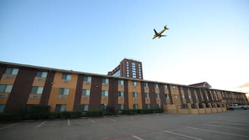 A multi-story hotel with a parking lot in front.