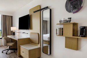 Hotellihuoneessa on työpöytä, tuoli ja suuri peili. Seinälle on asennettu televisio, ja huoneessa on myös kahvinkeitin sekä hylly, jossa on hygieniatuotteita.