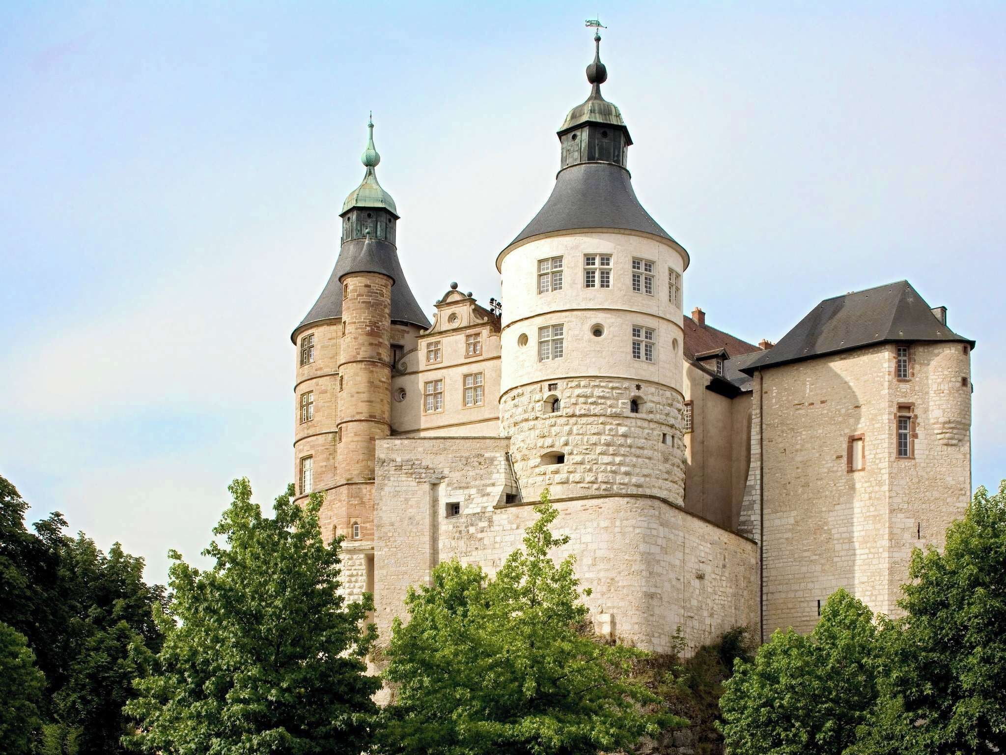 Un castillo histórico con múltiples torres y un muro fortificado.
