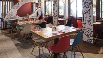 A restaurant interior with tables, chairs, and a person walking.