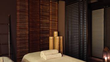 Experience tranquility in this serene spa room with a massage table and space.