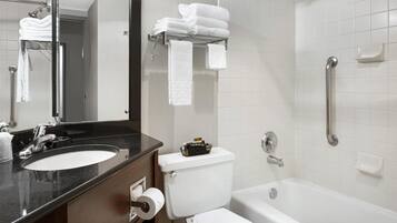 A bathroom with a sink, toilet, and bathtub. There are towels on a rack and a mirror above the sink.