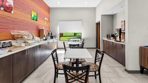 Una cocina moderna con bufé, un comedor con mesa y sillas, y vistas a un paisaje verde por una ventana.