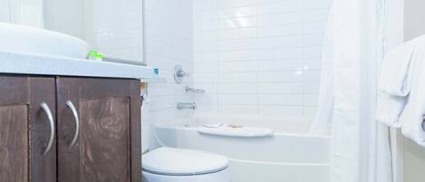 Un baño con inodoro blanco, bañera y ducha.