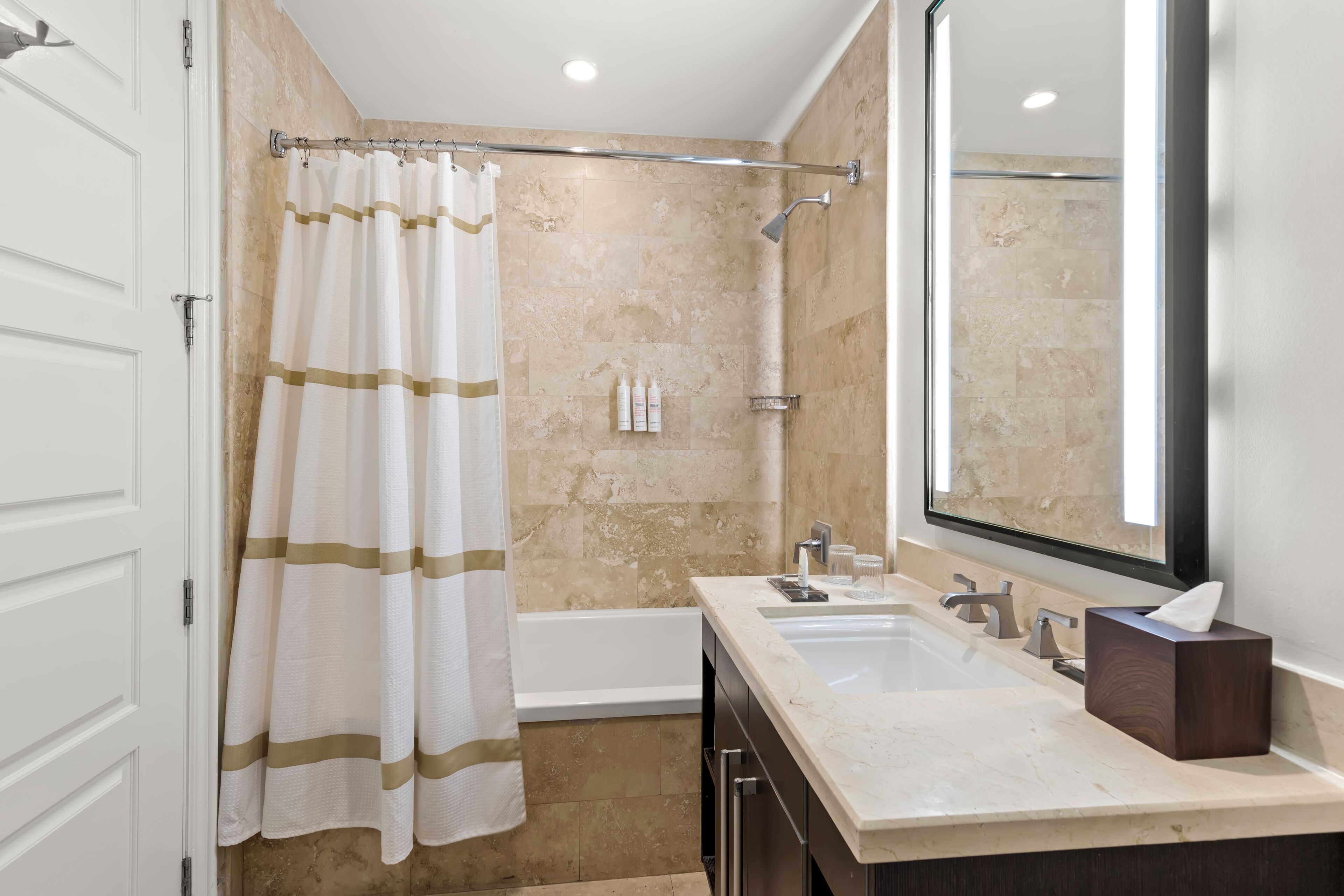 Une salle de bain équipée d’une douche, d’une baignoire, d’un lavabo et d’un miroir.