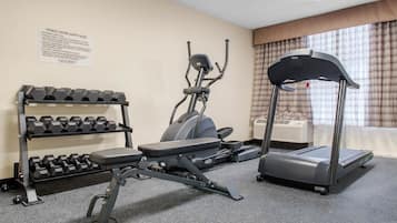 A fitness center with dumbbells, an elliptical, and a treadmill.