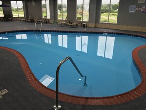 Una piscina cubierta, sombrillas, tumbonas