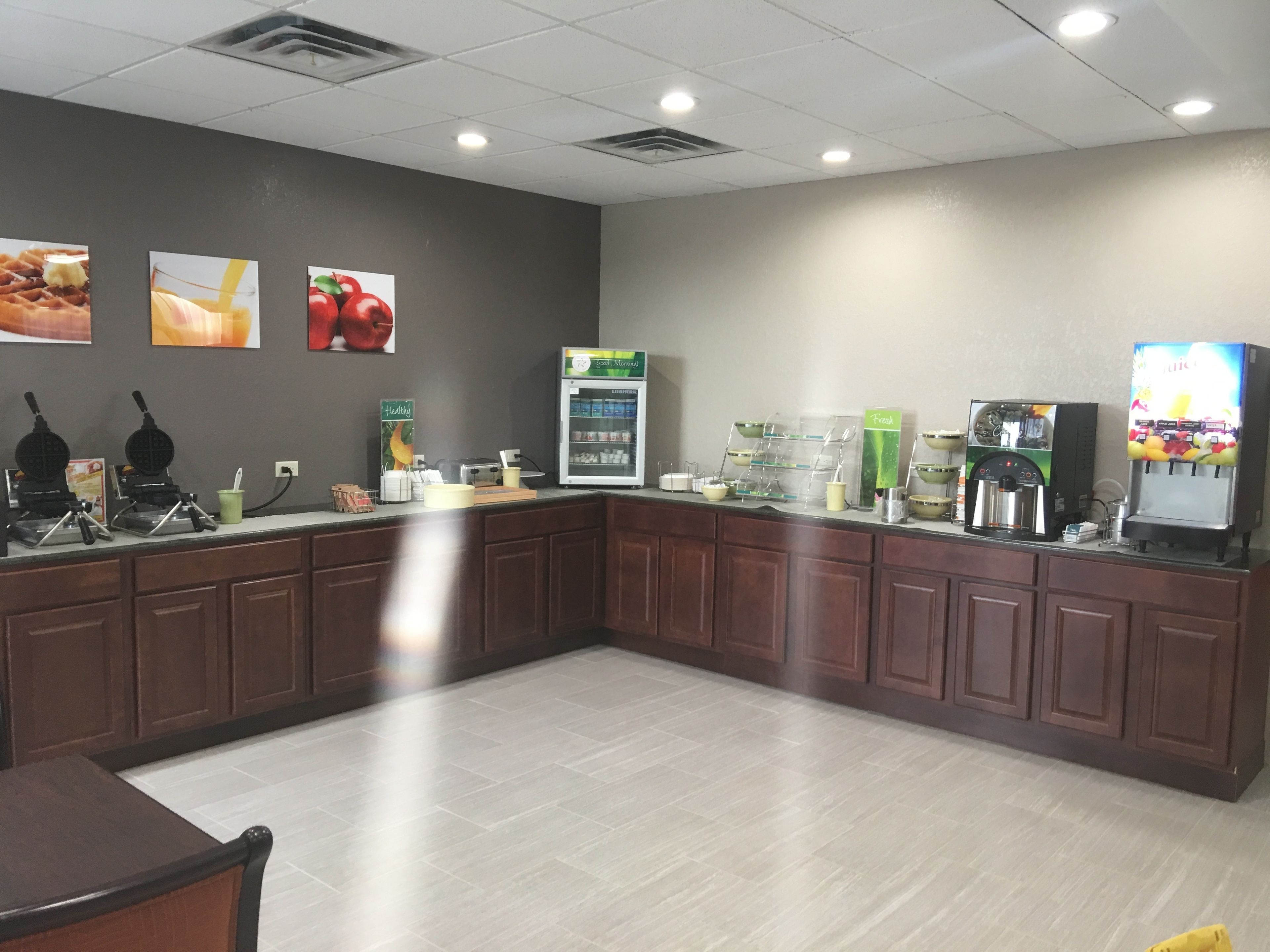 A clean, modern cafe with a counter, coffee machines, and a refrigerated display.