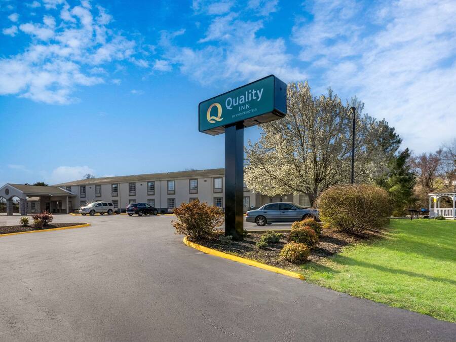 L’entrée d’un hôtel, avec une enseigne indiquant : « Quality Inn by Choice Hotels ».