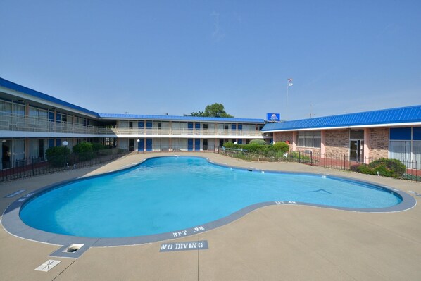 Um motel com piscina, teto azul e uma bandeira.