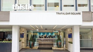 A hotel entrance with a 'thistle' sign, 'Welcome to London' sign, and 'TRAFALGAR SQUARE' text. - Thistle Trafalgar - Leicester Square (London)