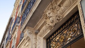 A building facade with ornate architectural details, including decorative metalwork and stone carvings. - Hôtel Oceania Le Métropole Montpellier (Montpellier)