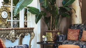 A luxurious interior with a grand clock, ornate furniture, and lush green plants. - Hôtel Oceania Le Métropole Montpellier (Montpellier)