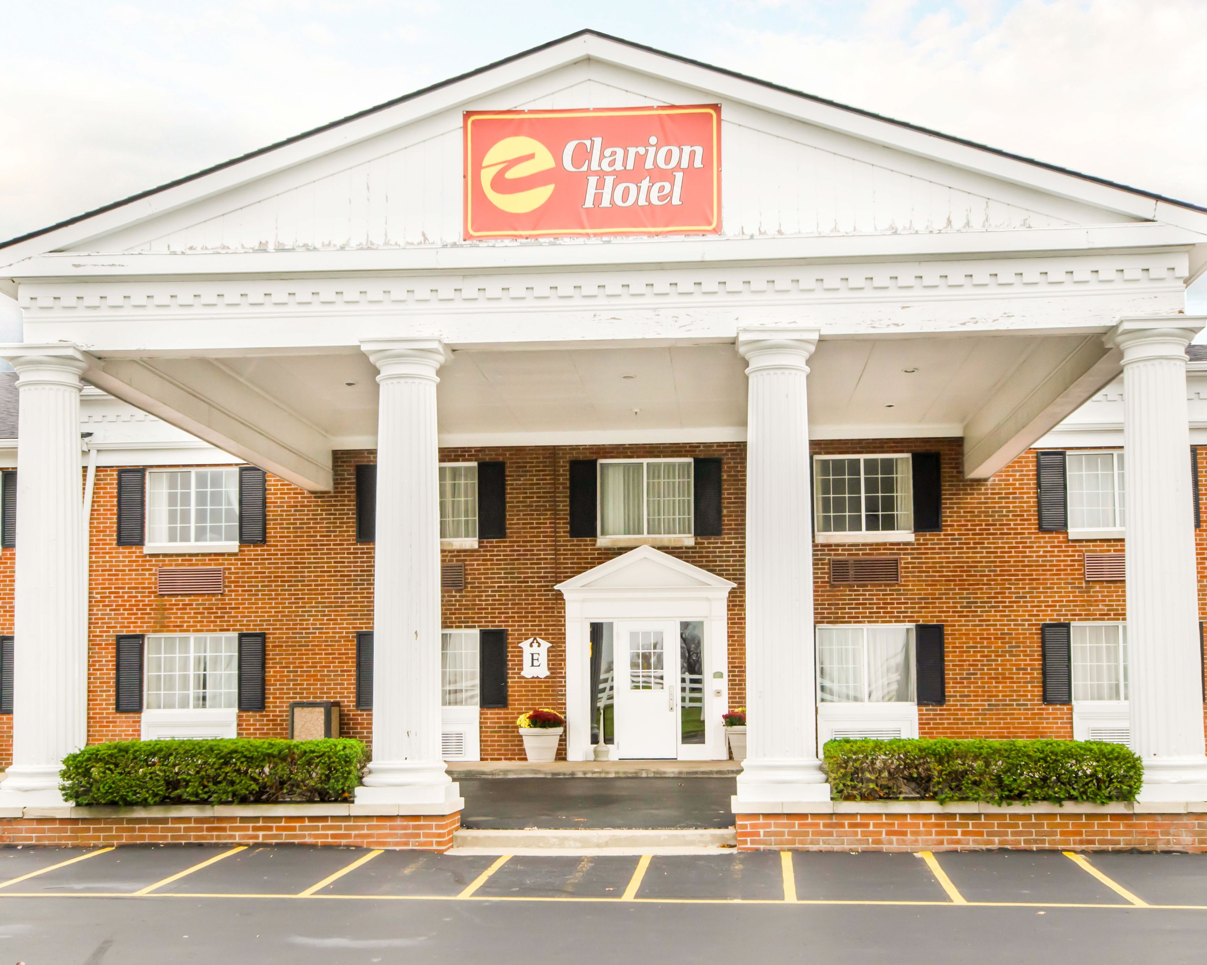 A hotel with a brick facade, white columns, and a sign reading "Clarion Hotel".