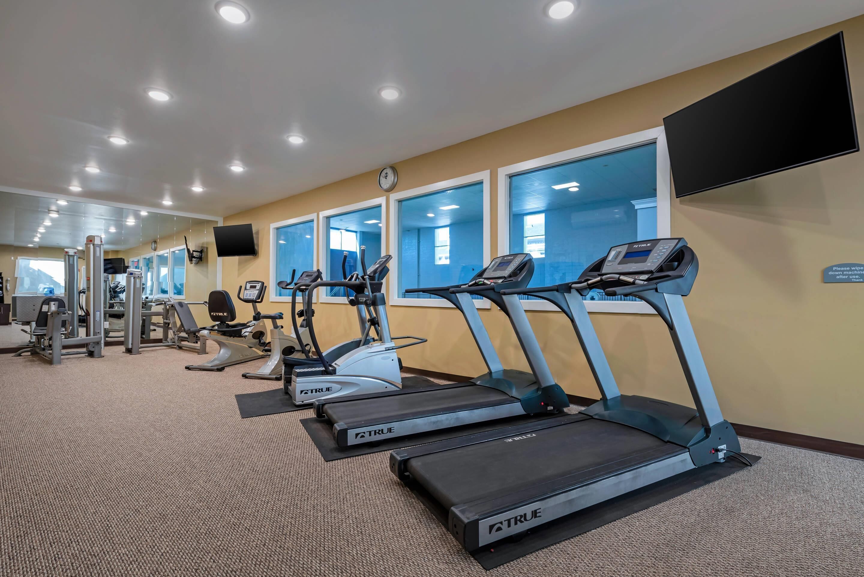 A gym with treadmills, exercise bikes, and weight machines.