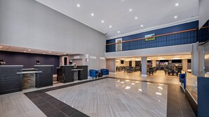 A spacious lobby with a reception desk, seating area, and a staircase leading to an upper level. - Clarion Hotel Conference Center Lexington North (Lexington)