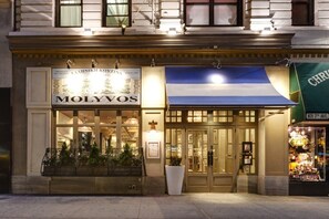 A building with a storefront named "MOLYVOS" and a large awning. - Wellington Hotel (New York)