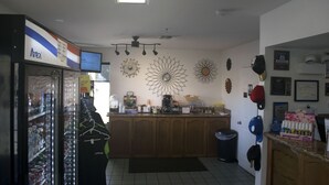 A kitchen with a refrigerator, coffee machine, and various kitchen items on the counter.