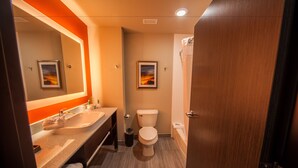 Un baño moderno con tocador doble lavamanos, inodoro y zona de ducha.