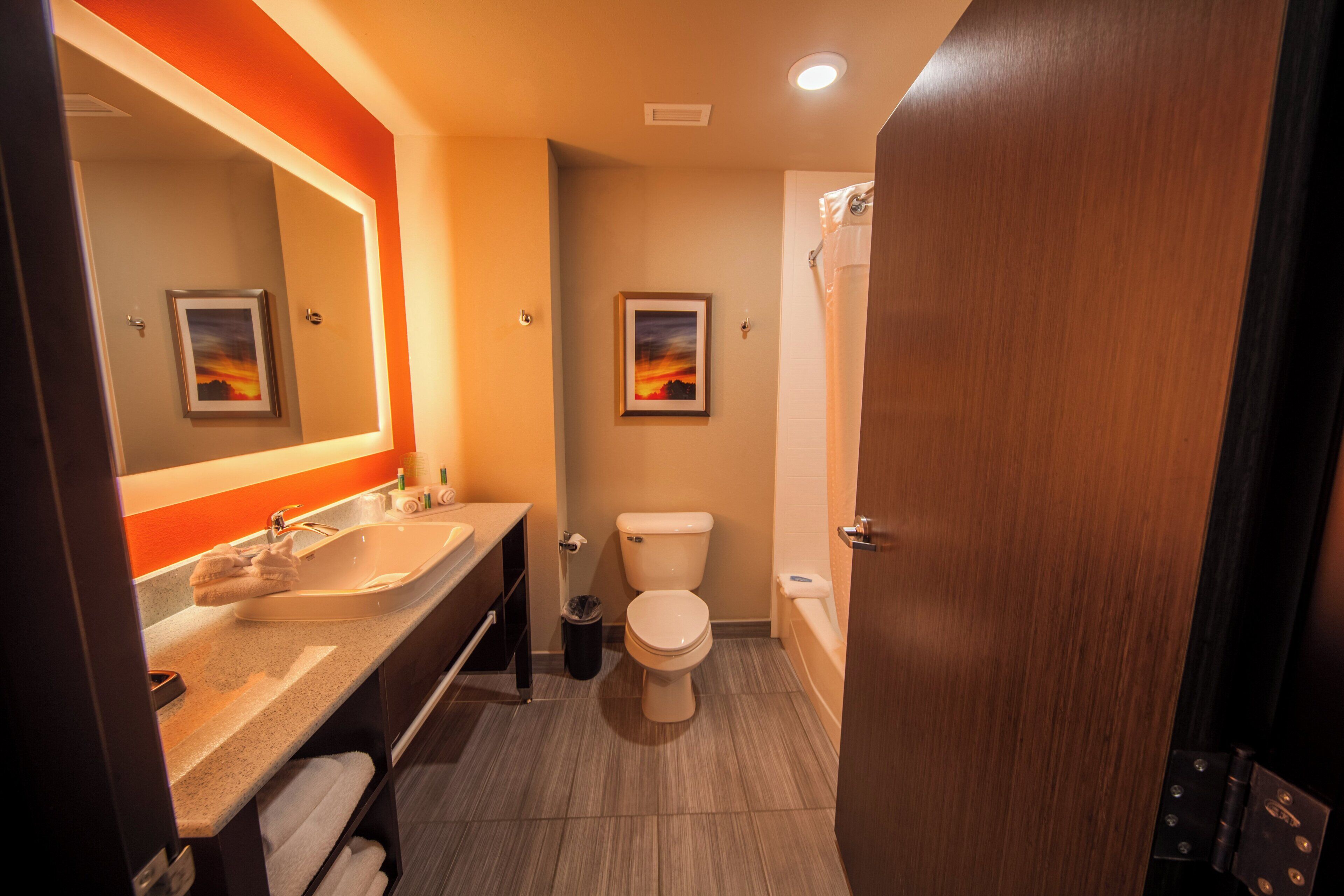 A modern bathroom with a sink, toilet, and shower.