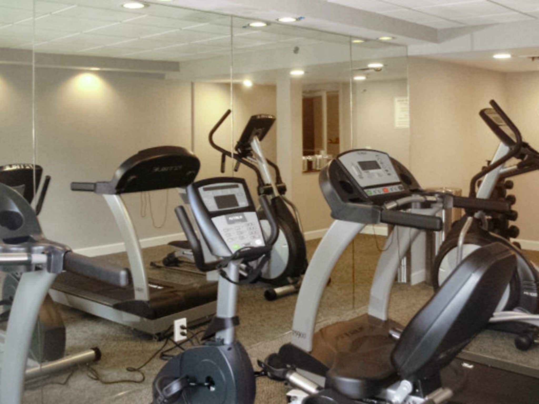 A fitness center with treadmills, elliptical machines, and a stationary bike.