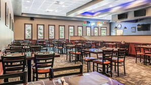 Un restaurant spacieux, doté de nombreuses tables et chaises, de grandes fenêtres et d’un plafond pourvu d’un éclairage encastré.