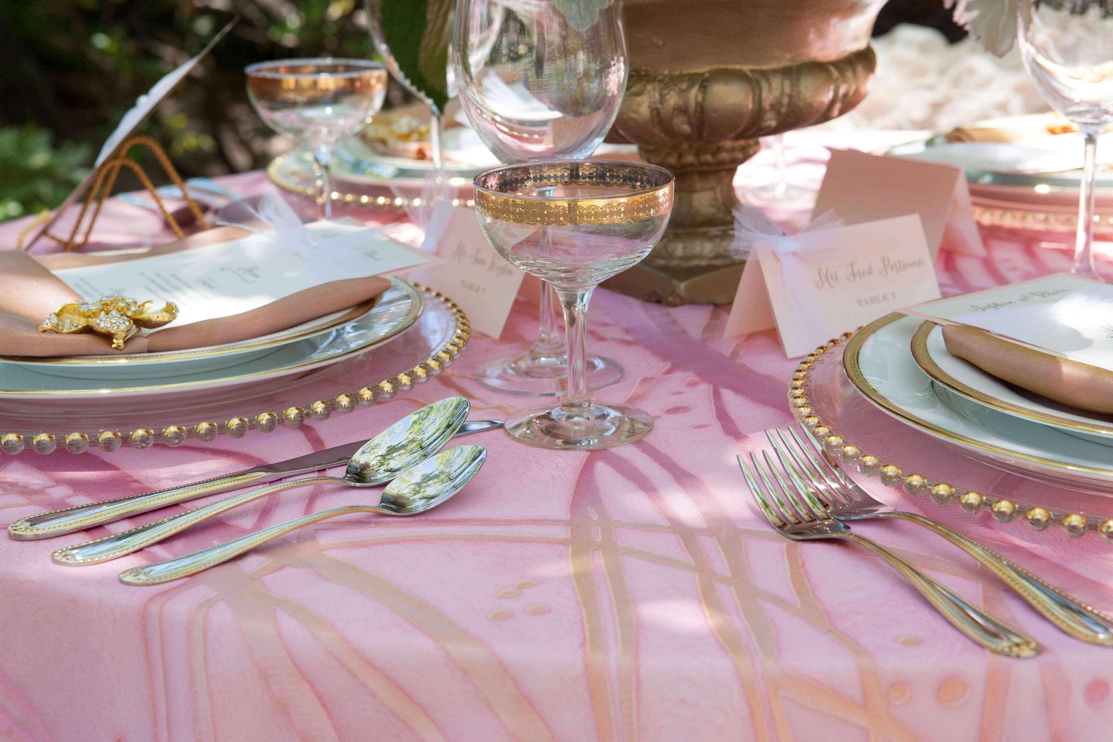 A table set with fine china, silverware, and glassware, indicating a formal dining arrangement.