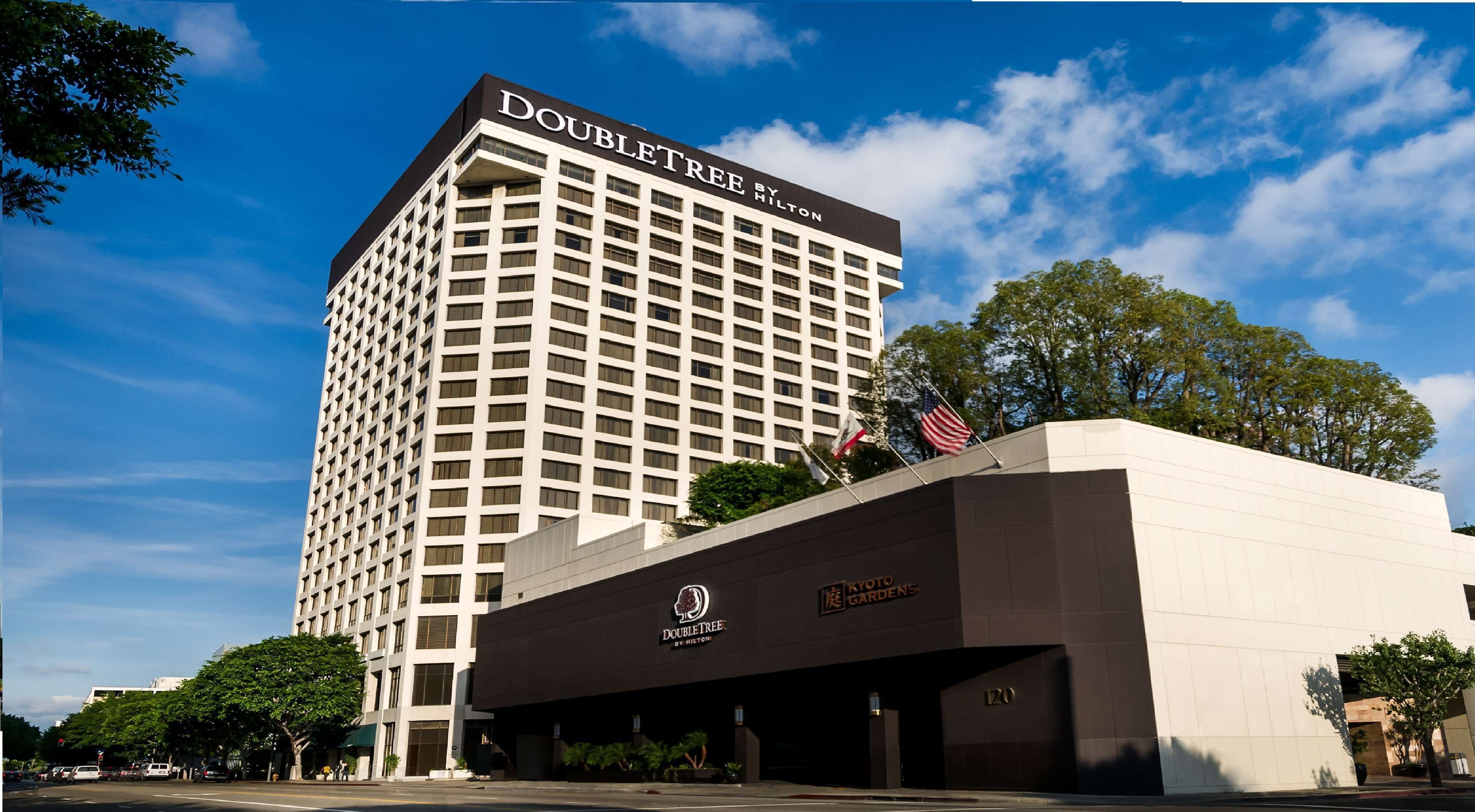 Een DoubleTree by Hilton hotel met een modern ontwerp, met een opvallende ingang en een vlag op het dak.
