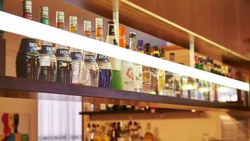 A bar with shelves stocked with various liquor bottles.