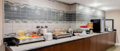 A buffet setup with various food items and appliances.