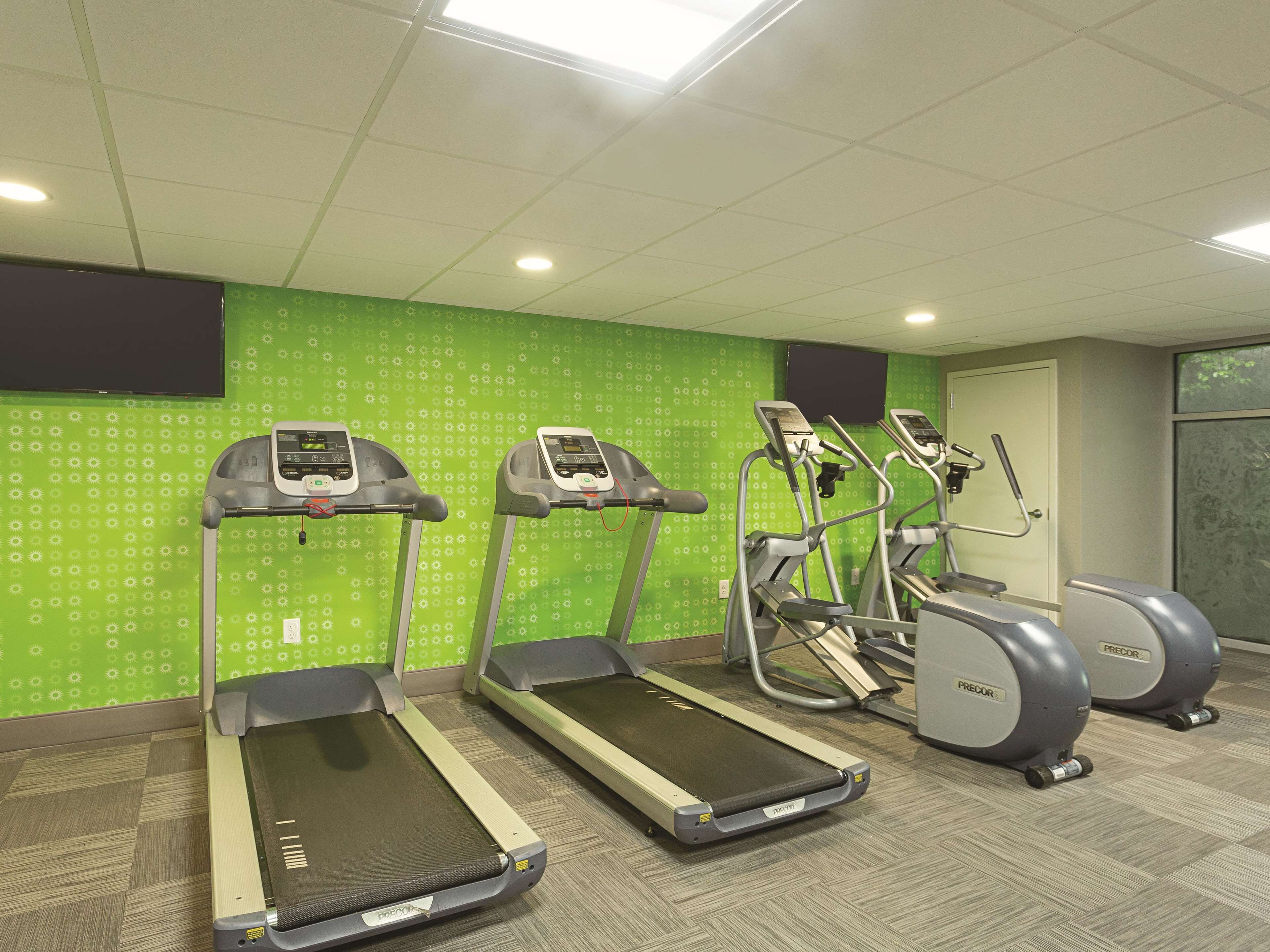 A fitness room with treadmills, an elliptical, and a stationary bike.