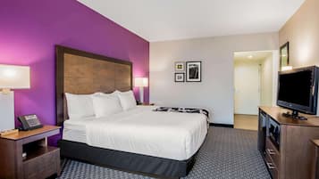 Hotelkamer met een groot bed, een bureau met telefoon, een televisietoestel en een tv aan de muur.