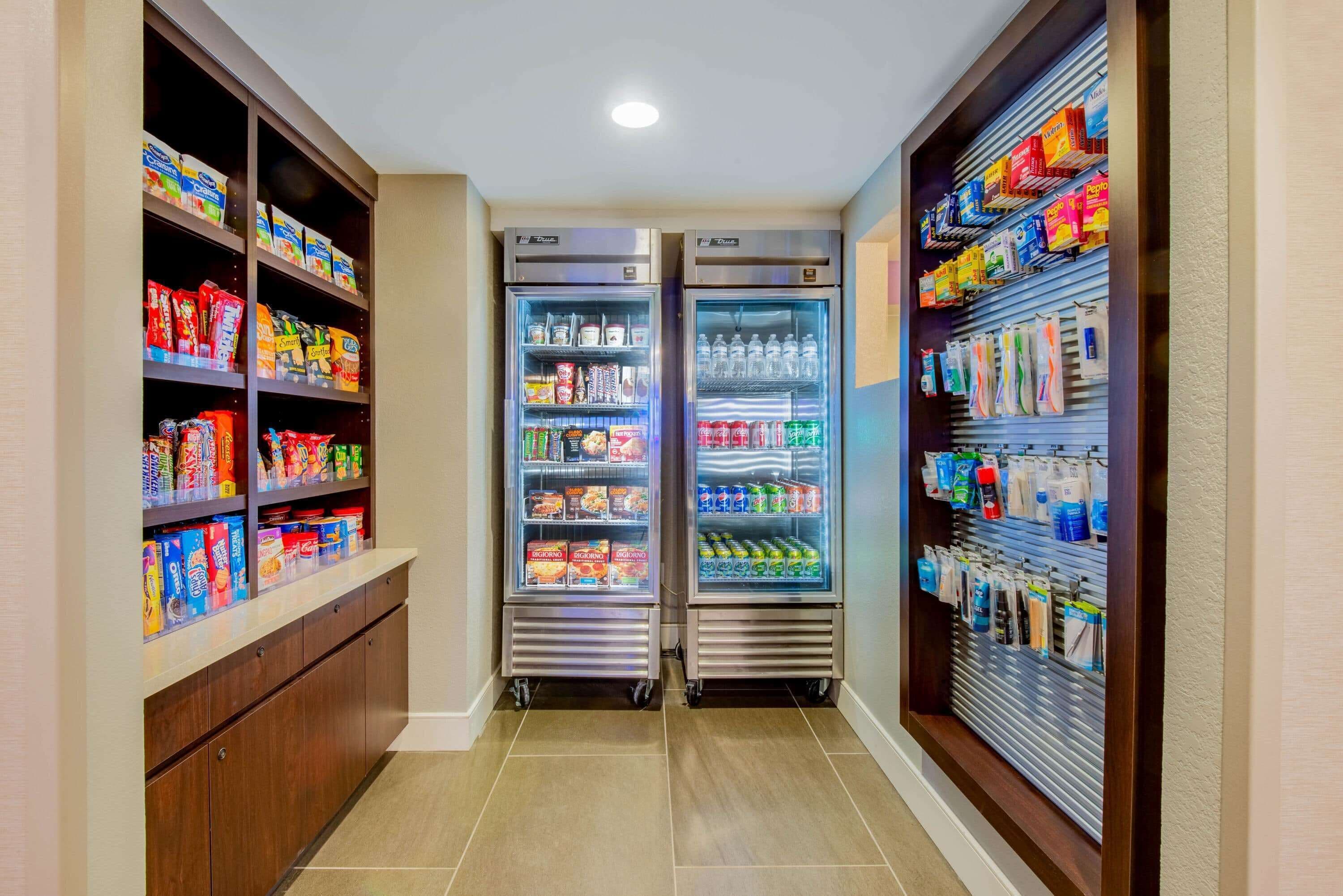 A narrow hallway with two beverage dispensers on either side, stocked with various drinks and snacks.