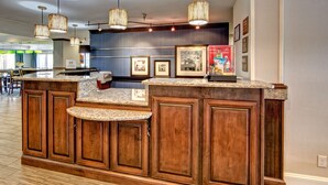 A kitchen with wooden cabinets, granite countertops, and hanging wicker chandeliers.