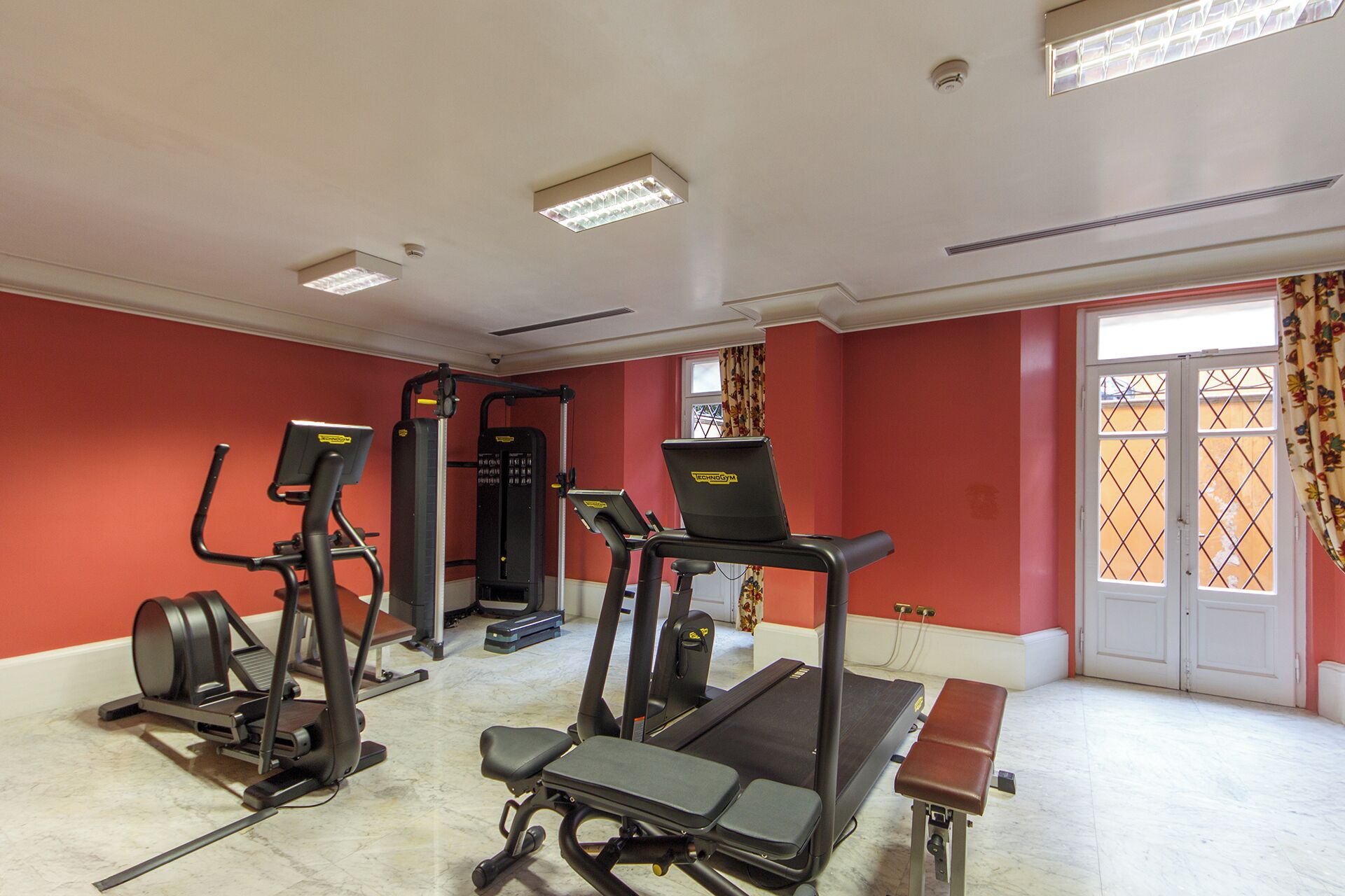 A gym with treadmills, elliptical machines, and weight equipment.