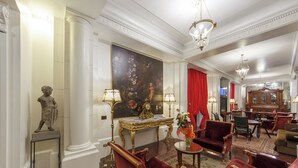 Una habitación lujosa con un cuadro grande, muebles elegantes y decoración clásica.