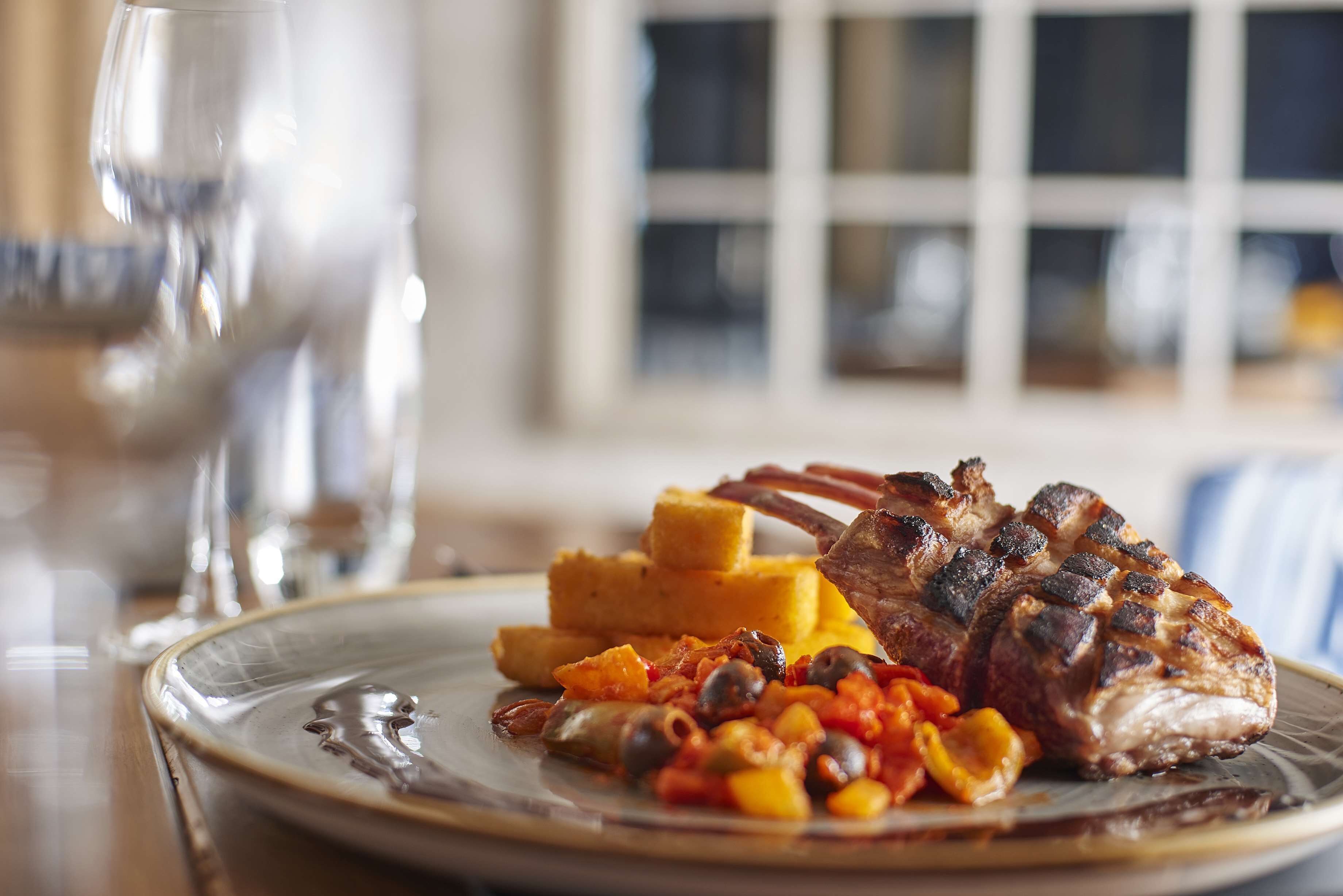A plate with grilled meat, vegetables, and corn.