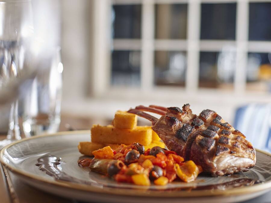 A plate with grilled meat, vegetables, and corn.