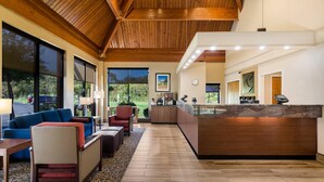 A spacious lobby with a wooden ceiling, large windows, a reception desk, and a seating area with a patterned rug. - Comfort Inn Lexington Virginia Horse Center (Lexington)