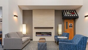 Un área de descanso moderna con chimenea, sofás y una mesita.