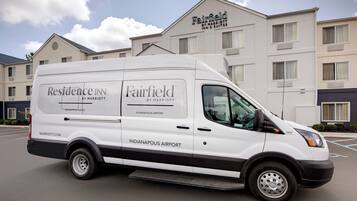 A white van with "Residence Inn by Marriott" and "Fairfield by Marriott" branding parked in front of a hotel.