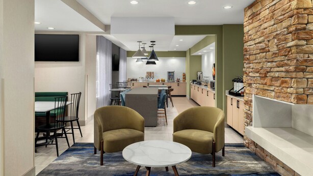 Un salon moderne avec un canapé, une table basse et un téléviseur.