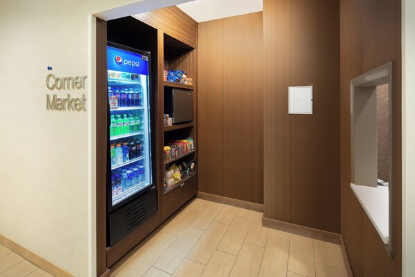 Un mercado de barrio con un refrigerador de Pepsi repleto de bebidas y aperitivos.