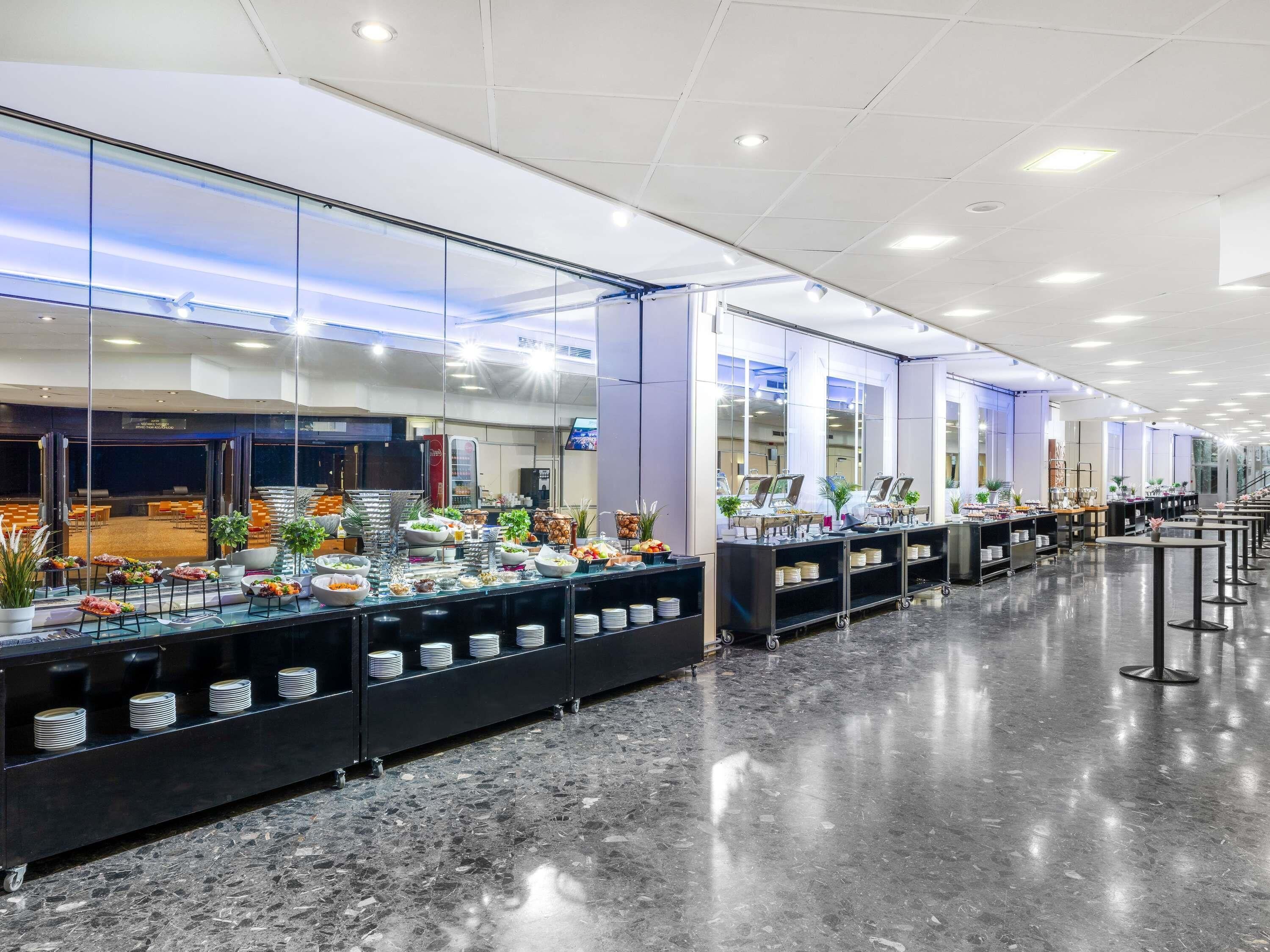 A buffet setup with multiple food stations, a polished marble floor, and a modern interior design.