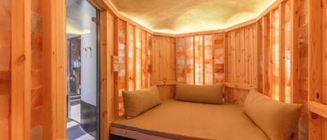 A wooden cabin with a built-in bench and a glass door leading to a bathroom.