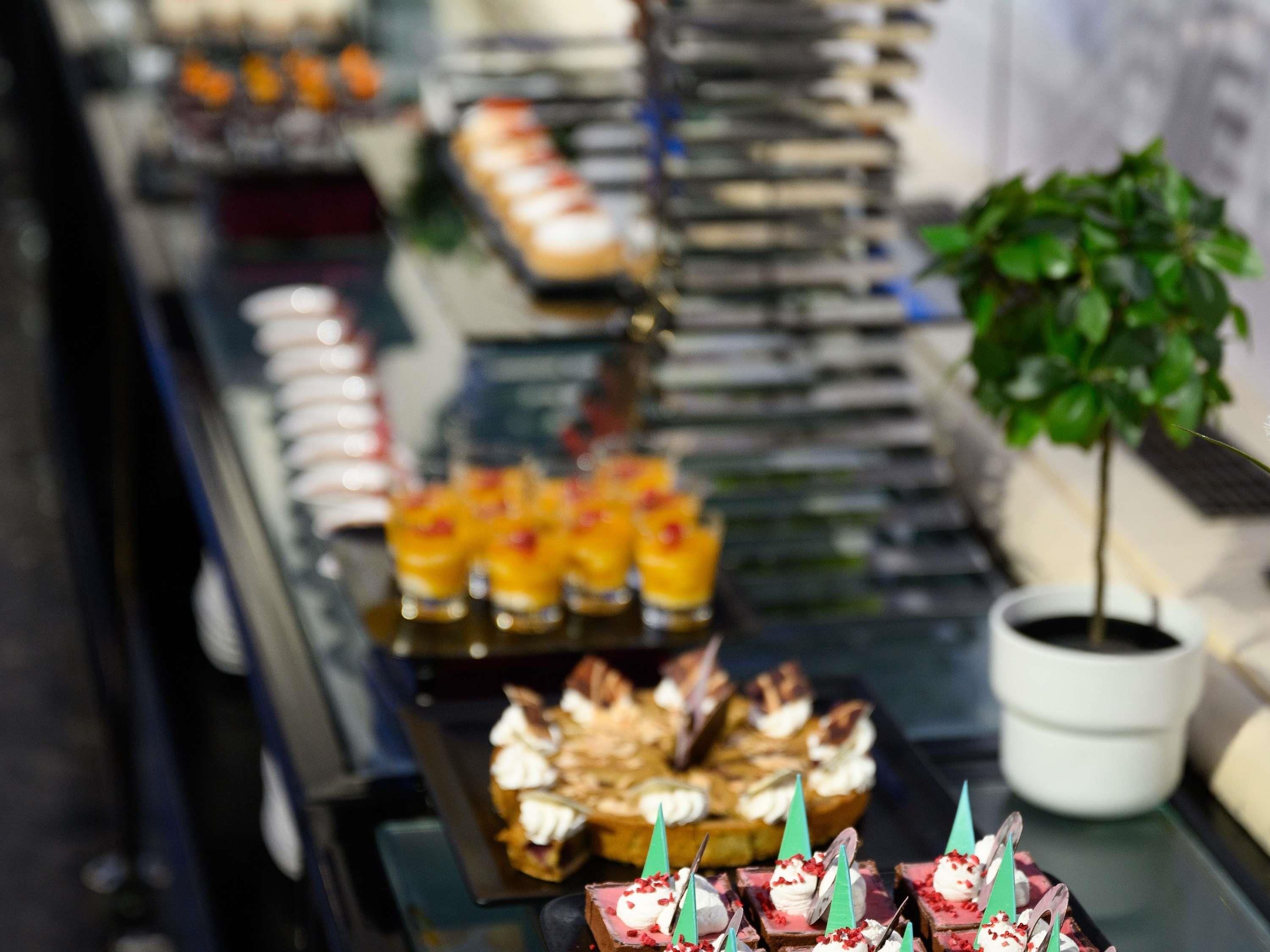 A buffet with various food items and a potted plant.