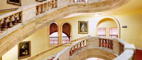 A grand marble staircase with multiple levels and red-carpeted steps.
